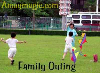 A Chinese family flies a kite inm Bailuzhou near the Xiamen Government building