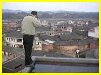 Babushka on the roof photographing a Tufang Hakka semi-walled village